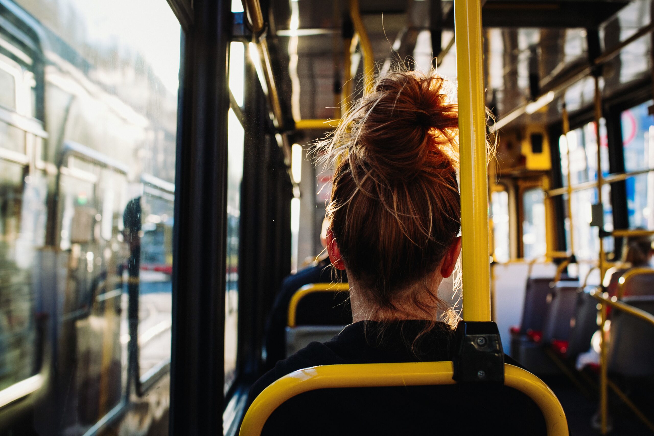 mulher sentada de costas em ônibus