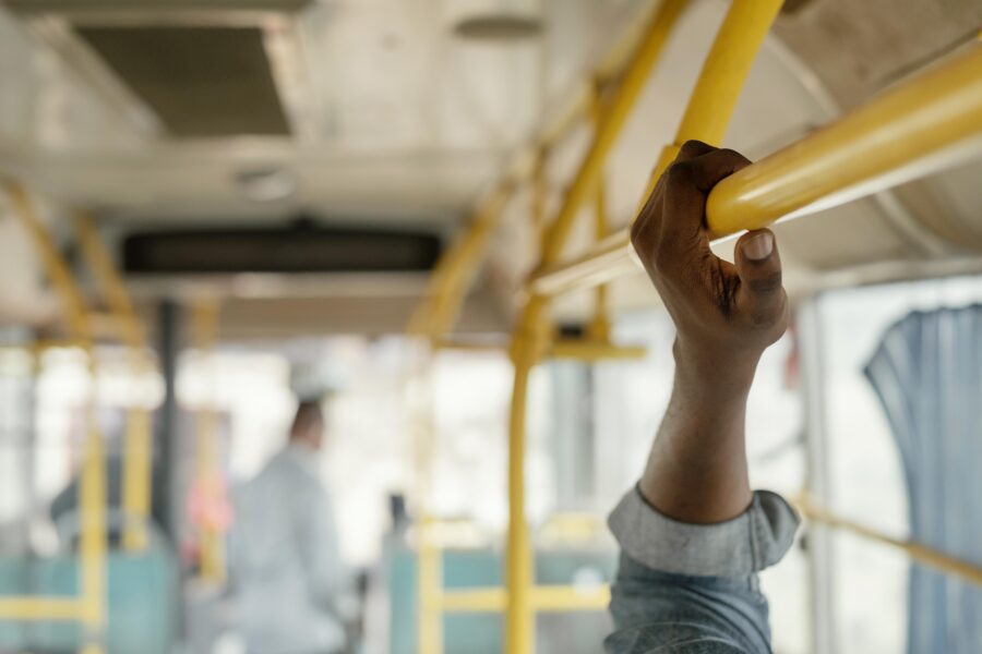 braço de homem segurando em interior de ônibus no melhor transporte público