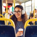 menina sentada em um ônibus, tomando café e ouvindo música olhando pela janela no melhor transporte público