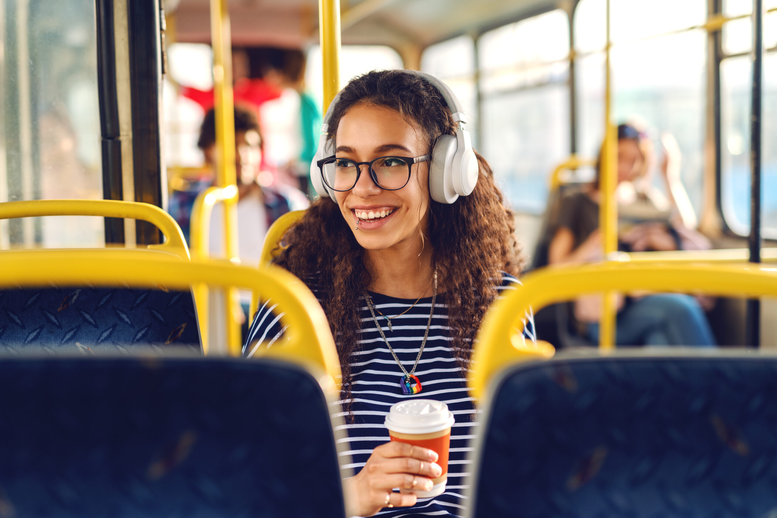 menina sentada em um ônibus, tomando café e ouvindo música olhando pela janela no melhor transporte público