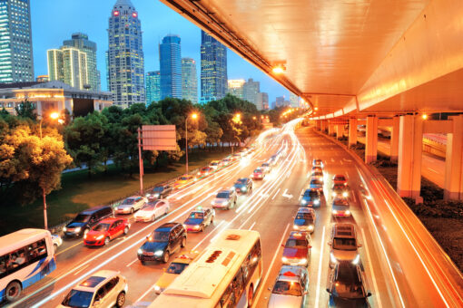 carros andando nas ruas com luzes e prédios